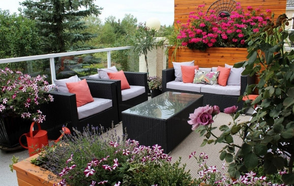 Vườn ban công trồng dạ yến thảo, hồng leo và hoa phong lữ xung quanh bàn ghế gỗ ngoài trời